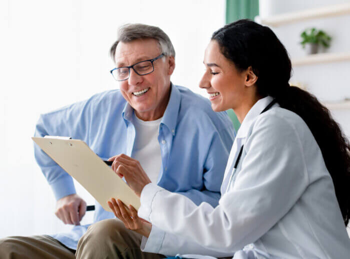 Doctor explaining to older male patient patient healthcare affordability