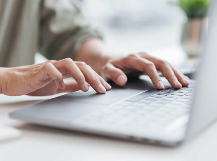 Hands typing on Laptop recourse vs non-recourse patient financing