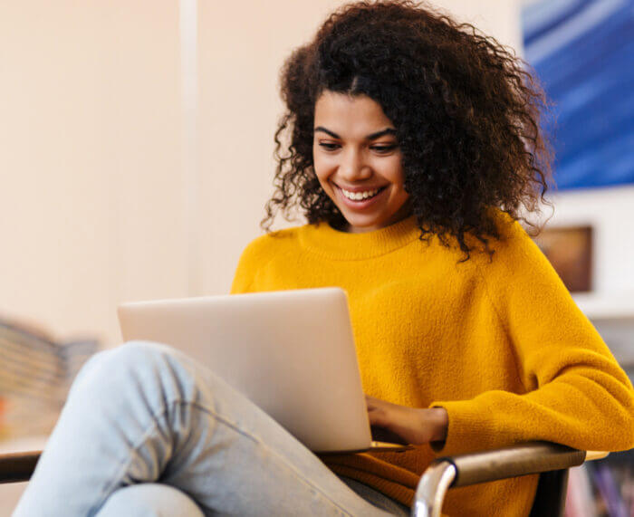 Woman Sitting on Chair With Laptop smiling about non-recourse patient financing